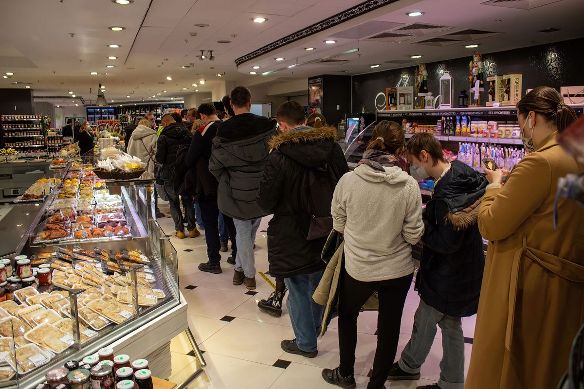 People line up to withdraw US dollars at an ATM in a supermarket in Moscow.