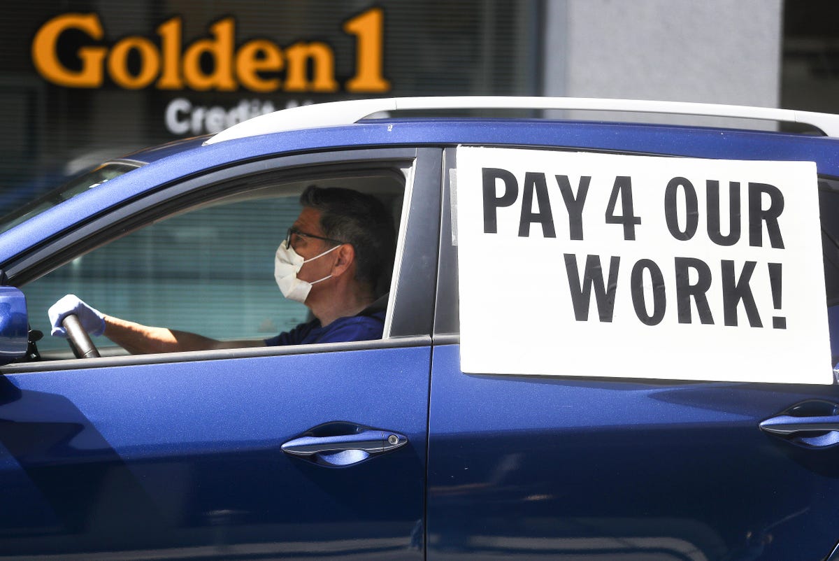 A ride-hail car with a sign on the window that reads